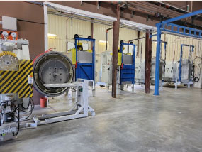 Extrusion die heat treatment department at Youngstown Tool & Die with vacuum chamber left and a bank of tempering furnaces.